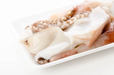 Köpük tepside taze çiğ mürekkep balığı bacakları.