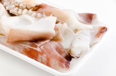 Köpük tepside taze çiğ mürekkep balığı bacakları.