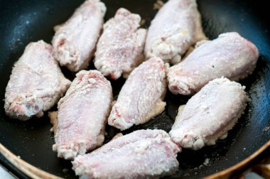 Tavuk kanatları tavada pişiyor