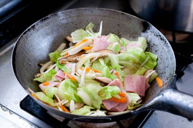 Stir-fried bacon and vegetables in a wok pan