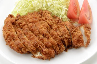 Chicken cutlet with shredded cabbage and tomato on plate on white background