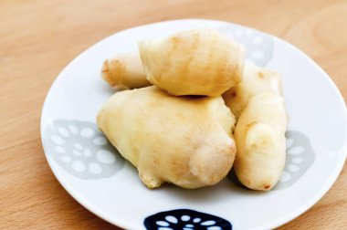 Bir tabakta soyulmuş zencefil kökü