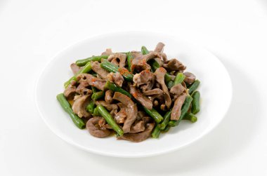 Kızarmış domuz kalbi ve beyaz arka planda yeşil fasulye..