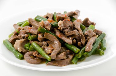 Kızarmış domuz kalbi ve beyaz arka planda yeşil fasulye..