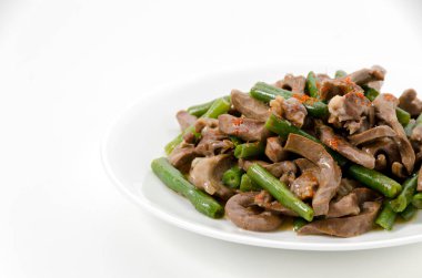 Kızarmış domuz kalbi ve beyaz arka planda yeşil fasulye..