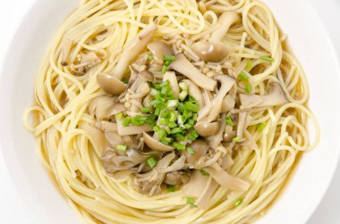 Beyaz arka planda Japon usulü mantar çorbası makarna.