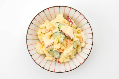 Beyaz arka planda makarna ve patates salatası.