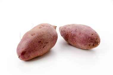 mor yer elması, beyaz arka planda mor tatlı patates.