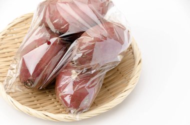 japanese sweet potatos(silk sweet) in plastic bag on white background