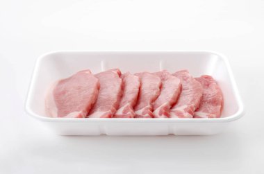 Beyaz arka planda köpük tepsisinin içinde domuz eti.