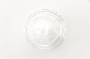 Beyaz arka planda izole edilmiş cam bir kase kabartma tozu. 