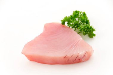 Beyaz arka planda maydanozlu taze ton balığı filetosu.