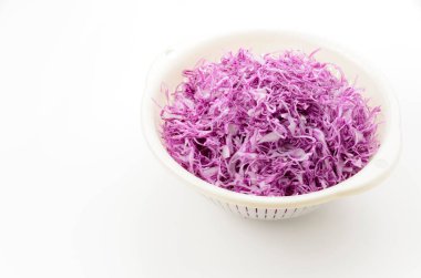 Beyaz arka planda kolander ve doğranmış kırmızı lahana 