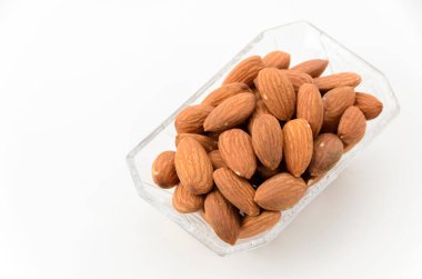 Beyaz arka planda küçük bir cam kasede jöleli badem.