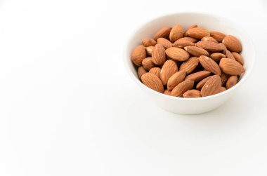 Beyaz arka planda beyaz bir kâse içinde jöleli bademler.