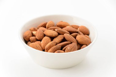 Beyaz arka planda beyaz bir kâse içinde jöleli bademler.