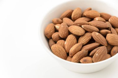 Beyaz arka planda beyaz bir kâse içinde jöleli bademler.