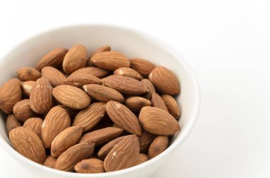 Beyaz arka planda beyaz bir kâse içinde jöleli bademler.