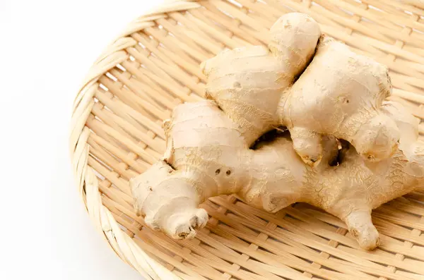 stock image fresh ginger on a bamboo strainer on white background 