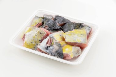 Beyaz arka planda köpüklü yemek tepsisinde mahi mahi balığı artıkları..