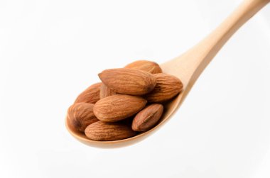 Beyaz arka planda badem ve tahta kaşık..