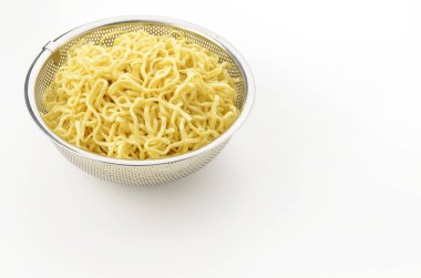 Okinawa soba eriştesi beyaz arka planda yağ boşaltmak için dayanıksız çelik kevgire konur. 