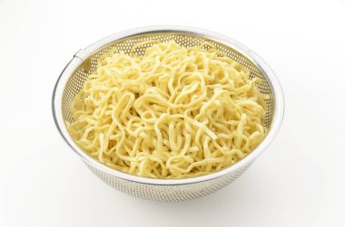 Okinawa soba eriştesi beyaz arka planda yağ boşaltmak için dayanıksız çelik kevgire konur. 