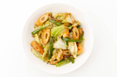 Karıştırılmış chikuwa, lahana ve yeşil biber kasede beyaz arka planda..