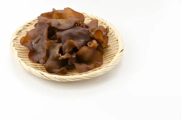 stock image Jew's ear mushroom in a bamboo strainer on white background