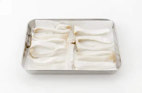 Stock image Arrange the sliced king oyster mushrooms on a stainless steel tray and sun-day them