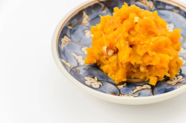 Küçük bir tabakta servis edilen ezilmiş fındıkla karıştırılmış kabaktan yapılmış bir salata.