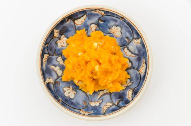 Küçük bir tabakta servis edilen ezilmiş fındıkla karıştırılmış kabaktan yapılmış bir salata.