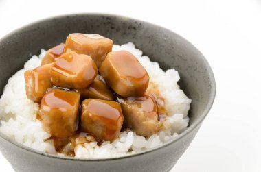 Bir kase beyaz pirinç, üstüne de izole edilmiş beyaz arka planda haşlanmış ton balığı.