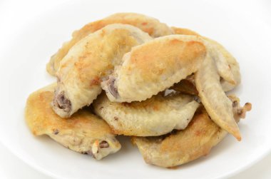 Beyaz tabakta tuzlanmış tavuk kanadı.