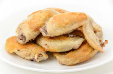 Beyaz tabakta tuzlanmış tavuk kanadı.