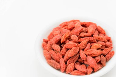 Beyaz arka planda kurutulmuş goji üzümleri.