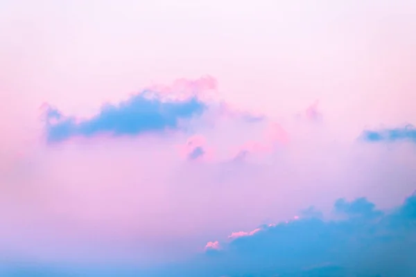 Abstract pastel wallpaper of the sky with pink and purple colored clouds during sunset.