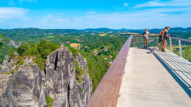 Kurort Rathen, Almanya - 18 Temmuz 2023: Turistler Bastei 'deki yeni modern izleme platformunda duruyorlar.