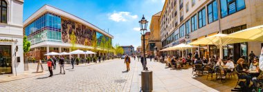 Dresden, Almanya - 3 Mayıs 2023: Tarihi şehir merkezi, Castle Caddesi, Kafesi, dükkanları ve insanları olan Kültür Sarayı. Modern ve enerjik görün Dresden. Şehir merkezinin güneşli bir günde ve mavi gökyüzünde.