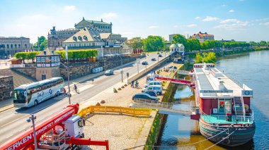 Dresden, Almanya - 25 Mayıs 2023: Eski şehir tarihi üzerine panoramik, Elbe nehri ve sıcak bahar gününde turistleri bekleyen büyük bir tur teknesi