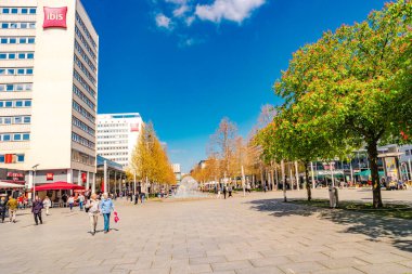 Dresden, Almanya - 3 Mayıs 2023: Kafesi, dükkanları ve insanları olan Prag Caddesi. Modern ve enerjik görün Dresden. Şehir merkezinin güneşli bir günde ve mavi gökyüzünde.