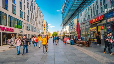 Dresden, Almanya - 3 Mayıs 2023: Kafesi, dükkanları ve insanları olan Prag Caddesi. Modern ve vibe Dresden ile panoramik manzara. Şehir merkezinin güneşli bir günde ve mavi gökyüzünde.