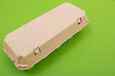 Kapalı yumurta kutusu ve on yumurta. Kutu paketi ya da yumurta kabını kapat. Tavuk yumurtalı yumurta kutusu, karton kutu ya da yumurta kabı. Yeşil arkaplan.