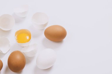 Tam beyaz ve kahverengi yumurta ve parlak bir arka planda yumurta sarısı. Seçici odak.