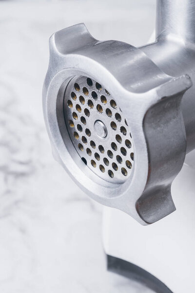 Meat grinder close-up on white background with copy space.