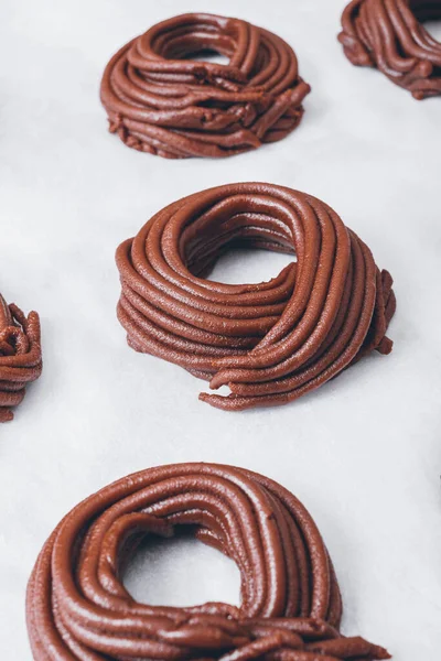 stock image Cacao dough for cookies, dough in the shape of a circle or a nest on parchment paper. Preparing process to baking. 