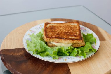 Marul, domates ve erimiş peynirli lezzetli bir sandviç..