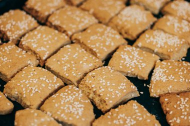 Square homemade cookies with sesame seeds.