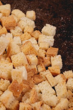 Pieces of roasted white bread in the baking tray. Close-up of delicious croutons.