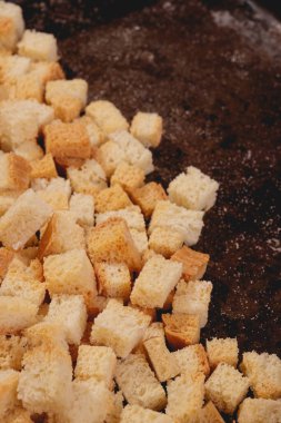 Pieces of roasted white bread in the baking tray. Close-up of delicious croutons.